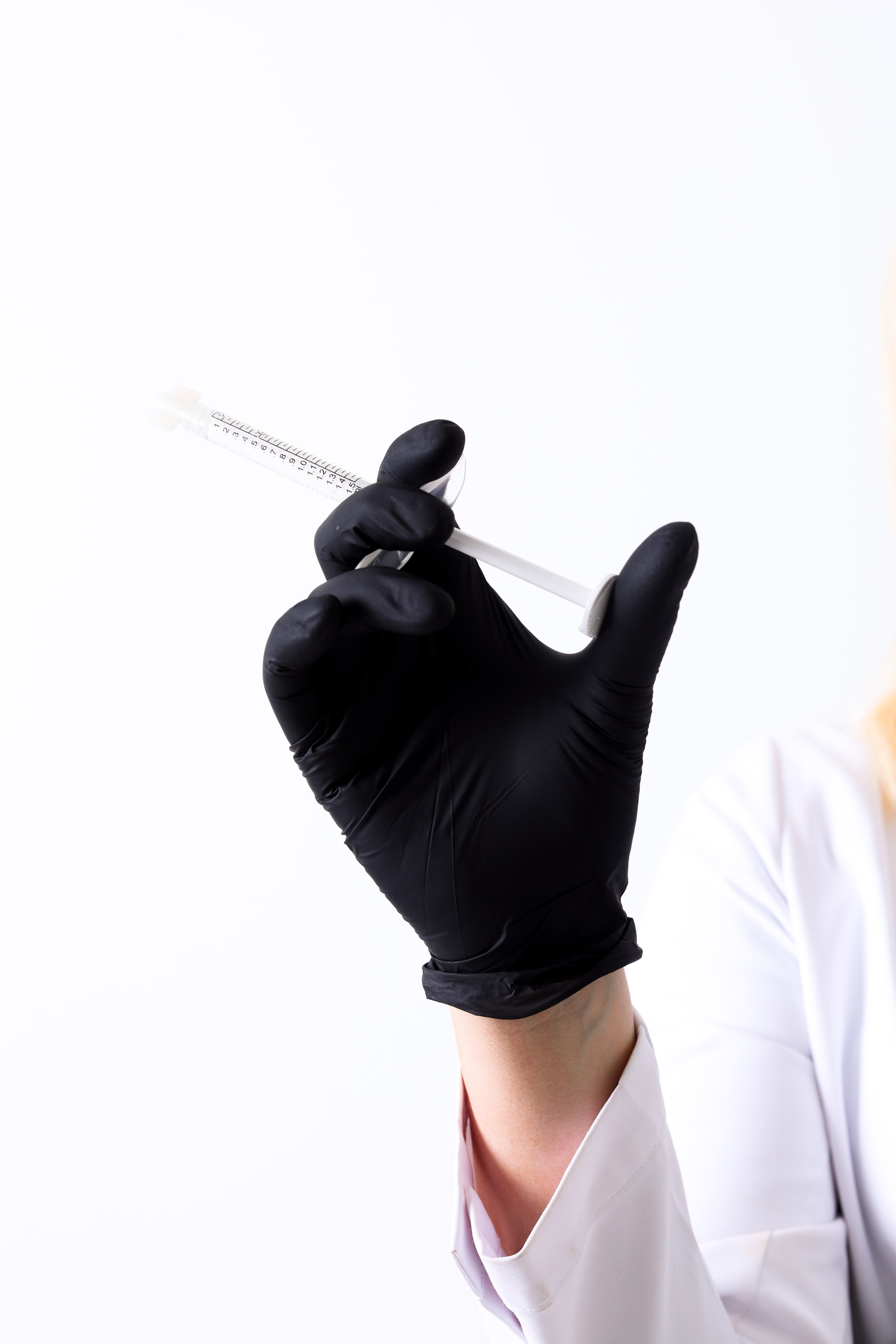 Gloved hand holding a syringe